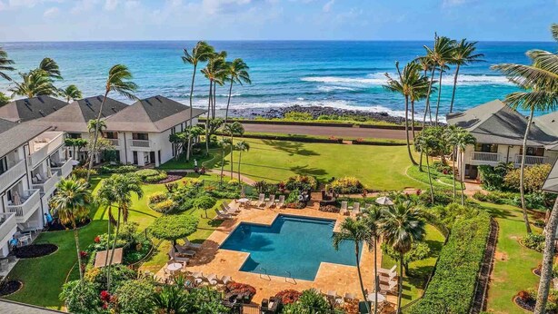A resort with a swimming pool, palm trees, and ocean views.