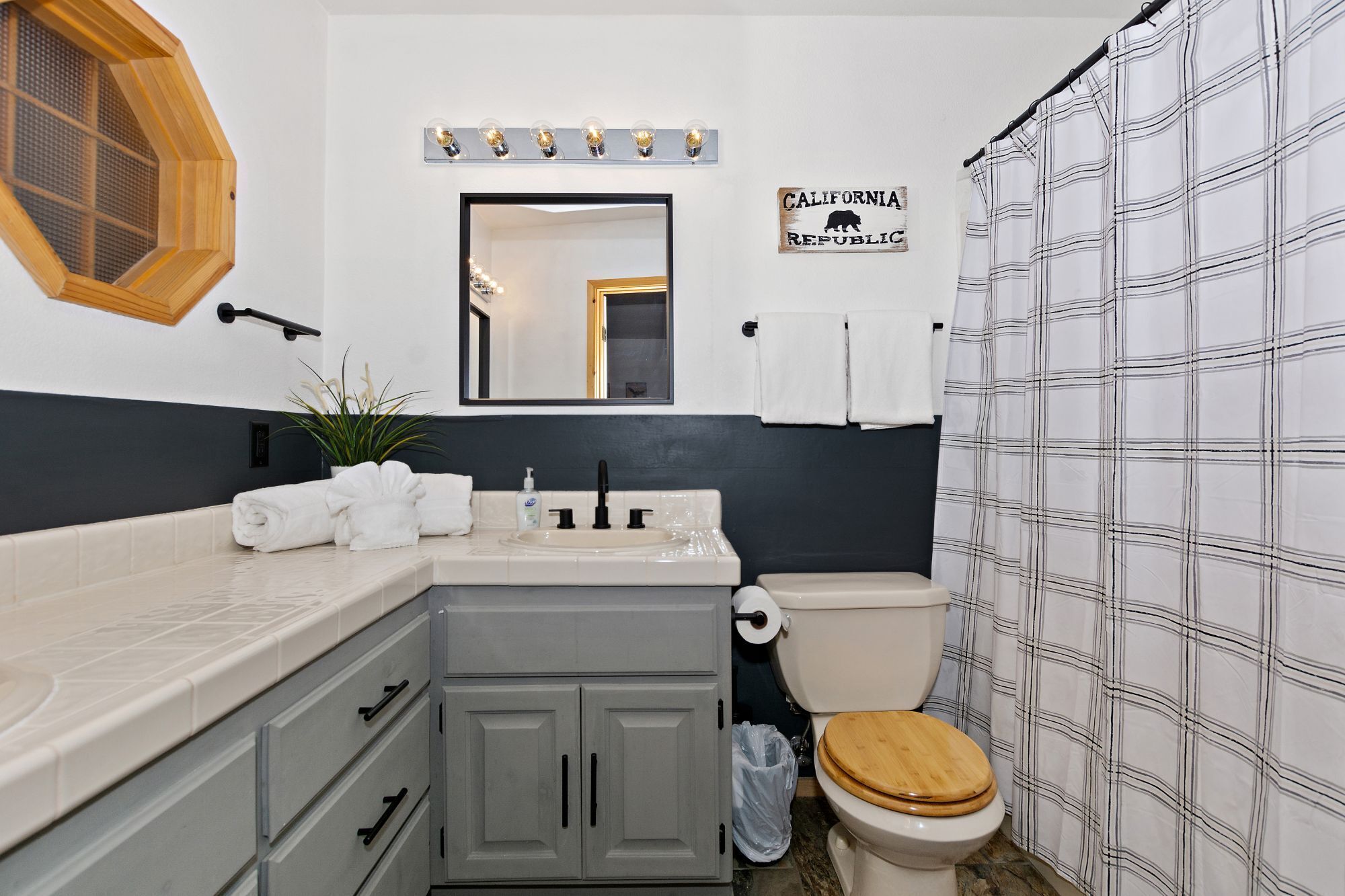 A bathroom with a toilet, sink, and a shower curtain.