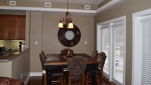 A dining area with a wooden table, chairs, and a wall clock.