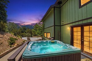 A hot tub in a landscaped outdoor area with a view of mountains.