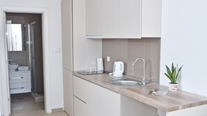 Una cocina moderna con armarios blancos, encimera de madera y un fregadero.