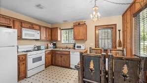 A kitchen with wooden cabinets, a white refrigerator, a stove, a microwave, and a dishwasher.