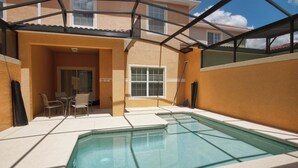 Uma piscina com um espaço coberto por uma varanda, uma janela e uma porta.