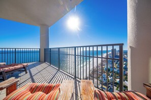 Un balcon avec vue sur l’océan et sur le paysage urbain.