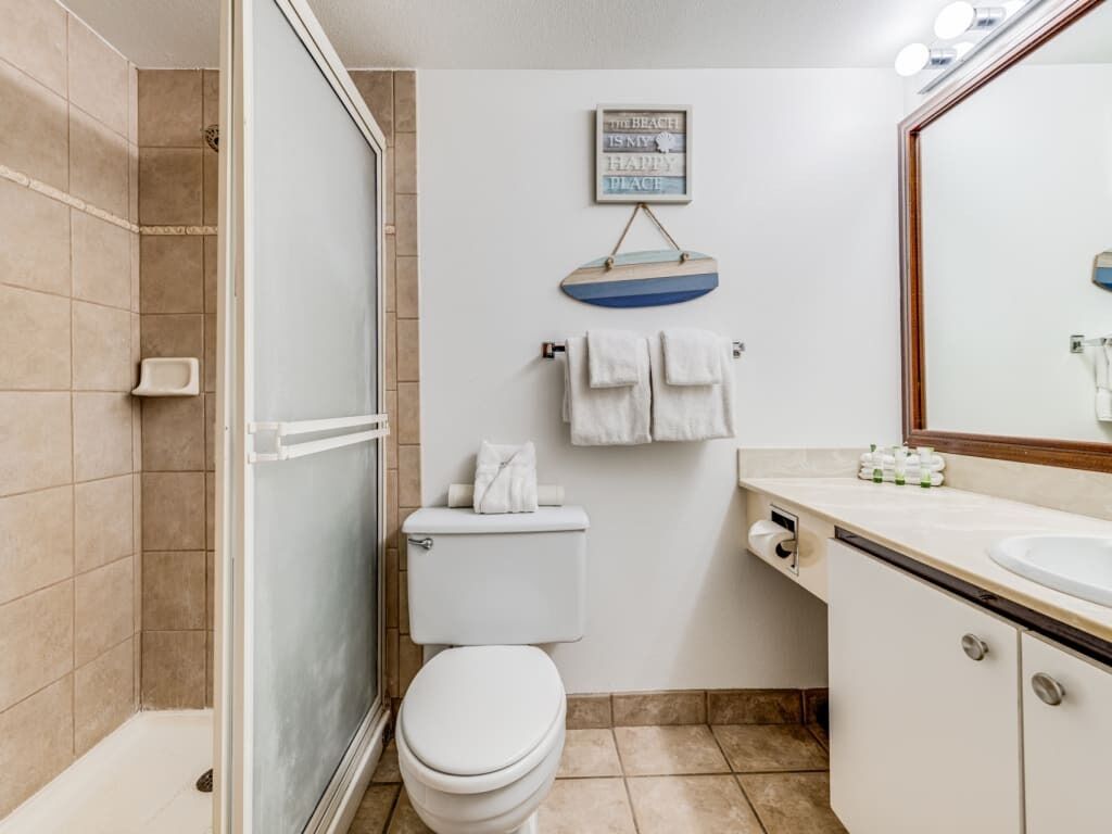 Une salle de bain avec des toilettes, une douche et un lavabo.