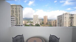 A balcony with a view of high-rise buildings, a tiled table, and two chairs. - KV1002 Waikiki 2463 Kuhio Ave Honolulu (Honolulu)