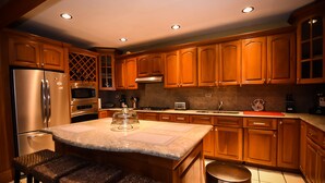 Una cocina moderna con armarios de madera, electrodomésticos de acero inoxidable y encimera de granito.