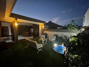 Une terrasse extérieure avec une piscine, un espace salon et une vue sur le paysage environnant.