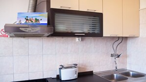 Una cocina con microondas, tostadora y un cuadro sobre el microondas.