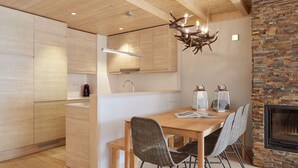 A modern kitchen with wooden cabinets, a built-in island, and a dining area with wicker chairs.
