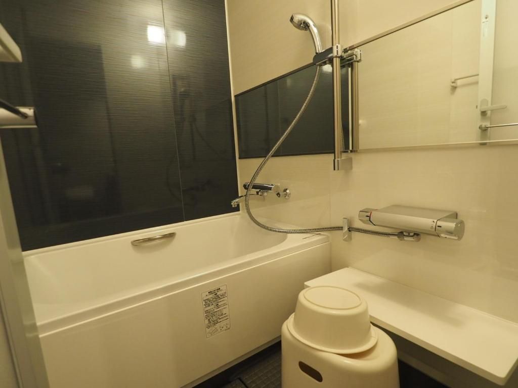 A bathroom with a bathtub, a toilet, a sink, and a mirror.