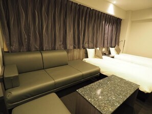 Une chambre d’hôtel moderne avec un canapé, un lit et une petite table.