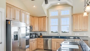 Una cucina moderna con mobili in legno, elettrodomestici in acciaio inossidabile e un'isola grande.