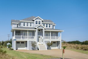 A two-story house with a front porch, a garage, and a small front yard.