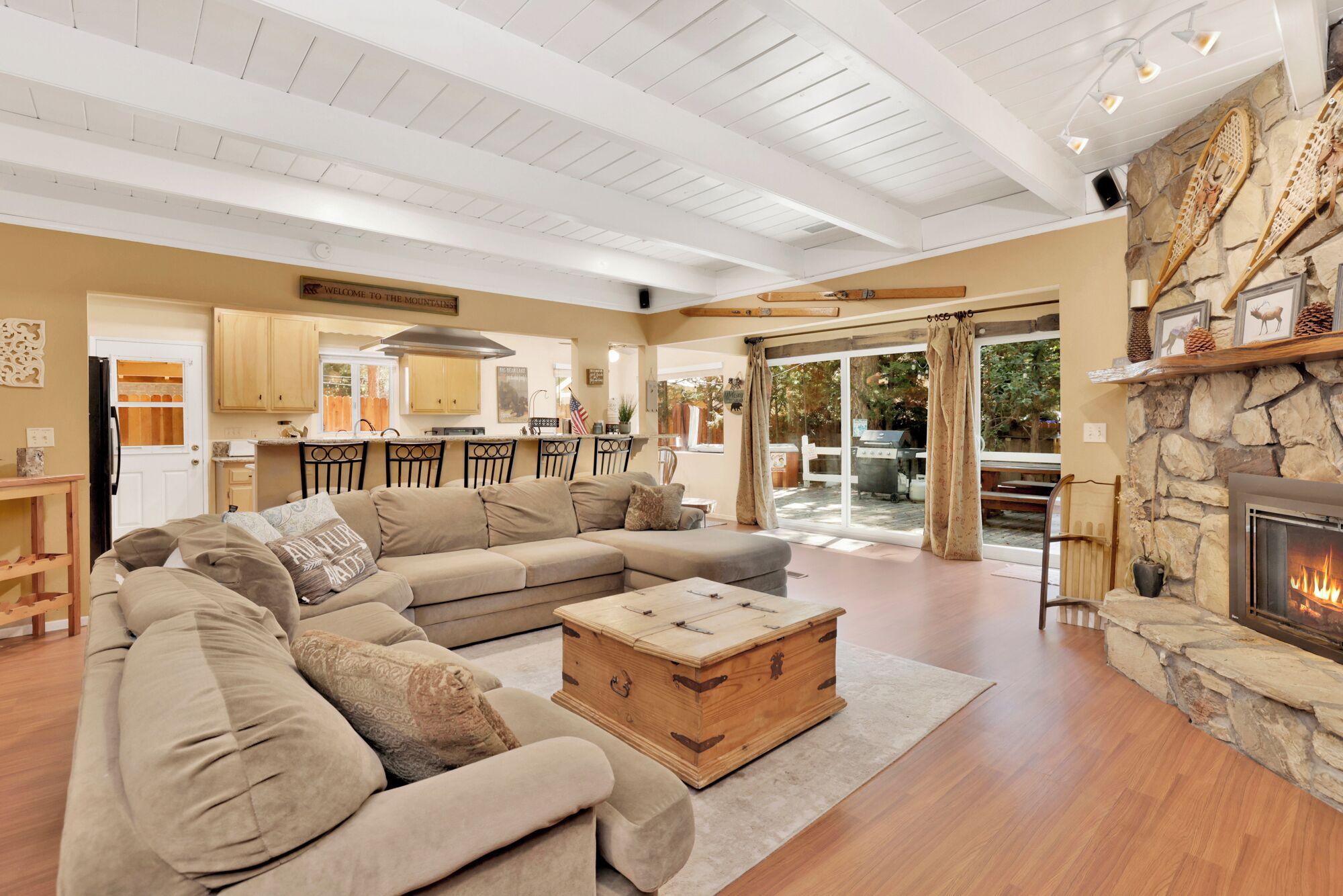 Cozy mountain living room with a stone fireplace, comfy seating, and smart TV—perfect for relaxing evenings, movie nights, and warm cabin vibes after outdoor adventures.