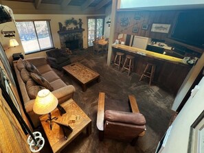 A cozy living room with a sofa, coffee table, and a bar area with stools. - 138 Standard by RedAwning (Mammoth Lakes)