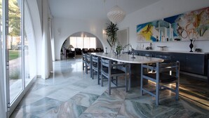A modern kitchen with a central island, bar stools, and a large window. - Villa with 7 rooms, swimming pool, tennis court and garden (Alvor)