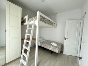 A room with bunk beds, a ladder, a door, and a small bedside table. - Chalet El Molino, with pool and chill-out (Chiclana de la Frontera)