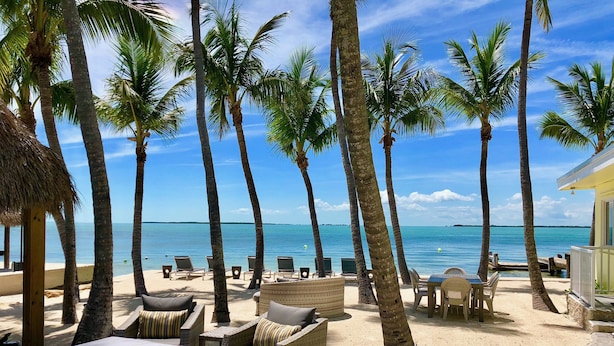A beachside lounge with wicker furniture and a view of the ocean. - Sunset Villas: Bayfront Beach Compound<br>**28 Night Min** (Key Largo)