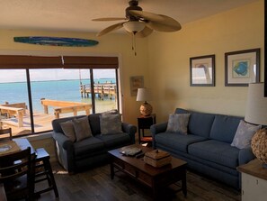 Relax in this inviting living room with a stunning sea view, featuring a sofa, coffee table, and artwork.