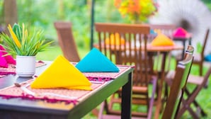 Una mesa con servilletas coloridas y una planta en maceta.