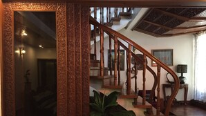 Una imponente escalera con detalles de madera elaborados y un espejo grande.
