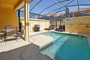 Une piscine intérieure avec des chaises longues et un barbecue.