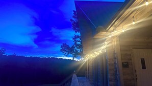 A wooden building with a porch, string lights, and a sign reading "Welcome to the Lodge."
