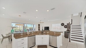 A modern kitchen with white cabinets, a granite countertop, and a built-in dishwasher.