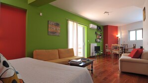 A room with a bed, two sofas, a coffee table, and a TV. - Acropolis Home (Athens)
