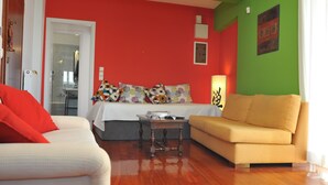 A room with a bed, a sofa, a table, and a lamp. - Acropolis Home (Athens)