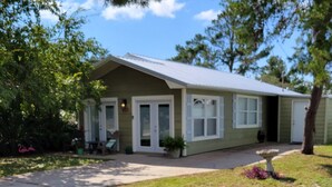 A single-story house with a front porch, a small garden, and a clear sky. - A Special Getaway! (Panama City Beach)