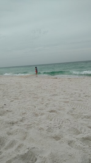 Una playa con una persona a lo lejos.