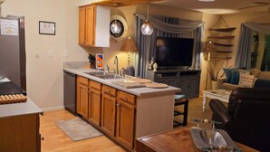 A modern kitchen with wooden cabinets, a built-in island, and pendant lighting. - A Special Getaway! (Panama City Beach)