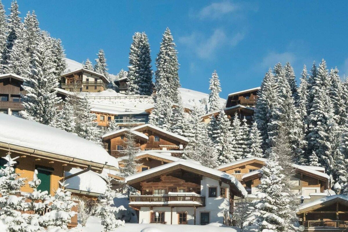 Ein schneebedecktes Bergresort mit mehreren Chaletbauten.