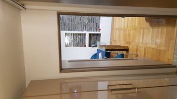 A modern room with a large window, a wooden desk, and a chair.