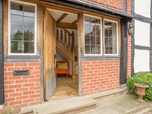 A traditional brick building with a wooden staircase leading to an upper floor.