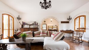 Ein gemütliches Wohnzimmer mit einer Eckcouch, Holzboden und einem Kronleuchter.