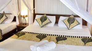 A hotel room with a bed, a nightstand, a lamp, and a canopy bed.