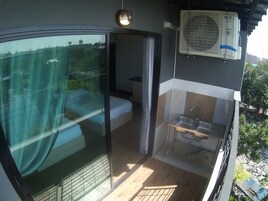 A balcony with a glass door, a small bathroom with a shower, and a sink.