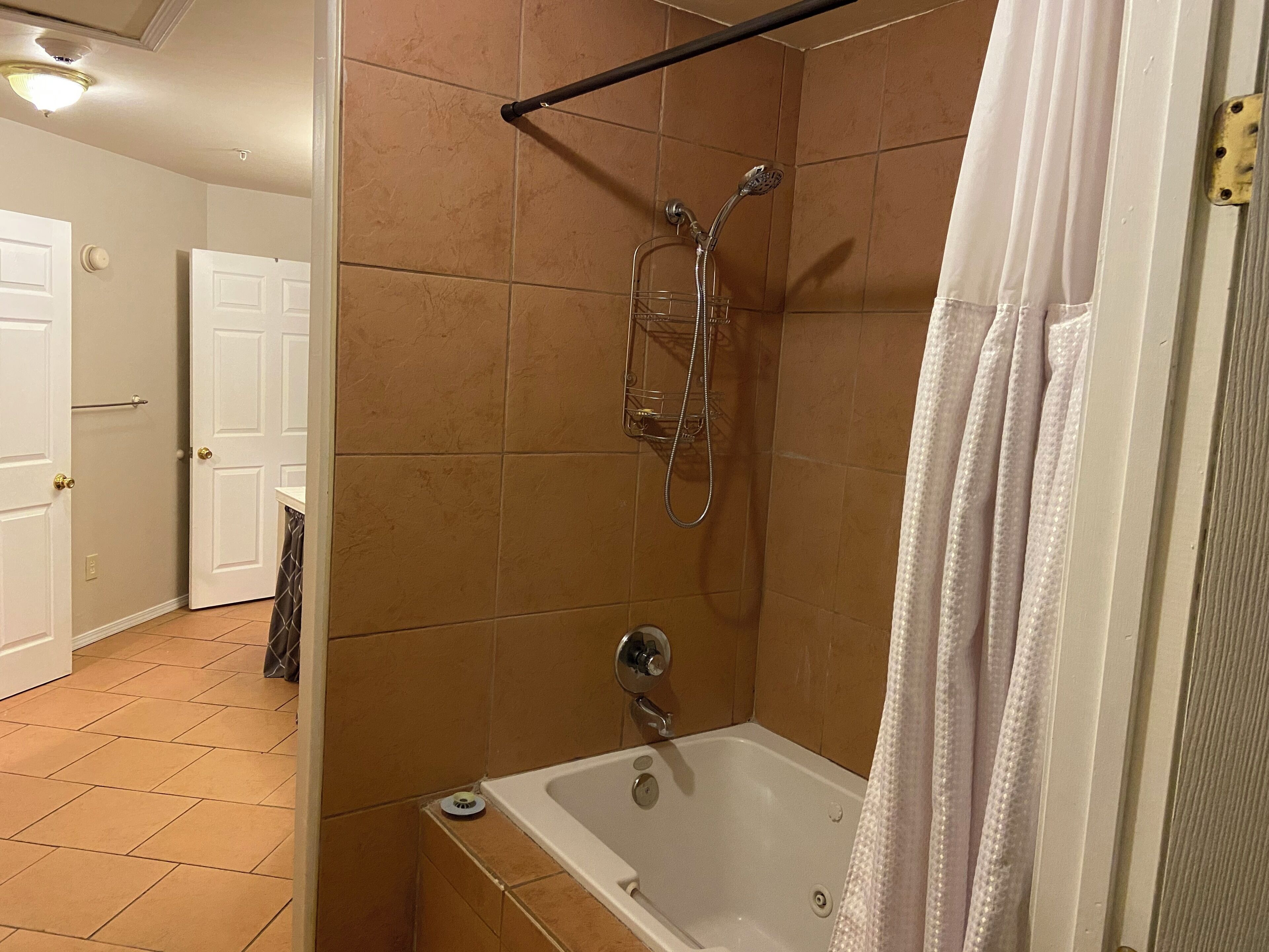 Un baño con ducha, bañera y retrete.