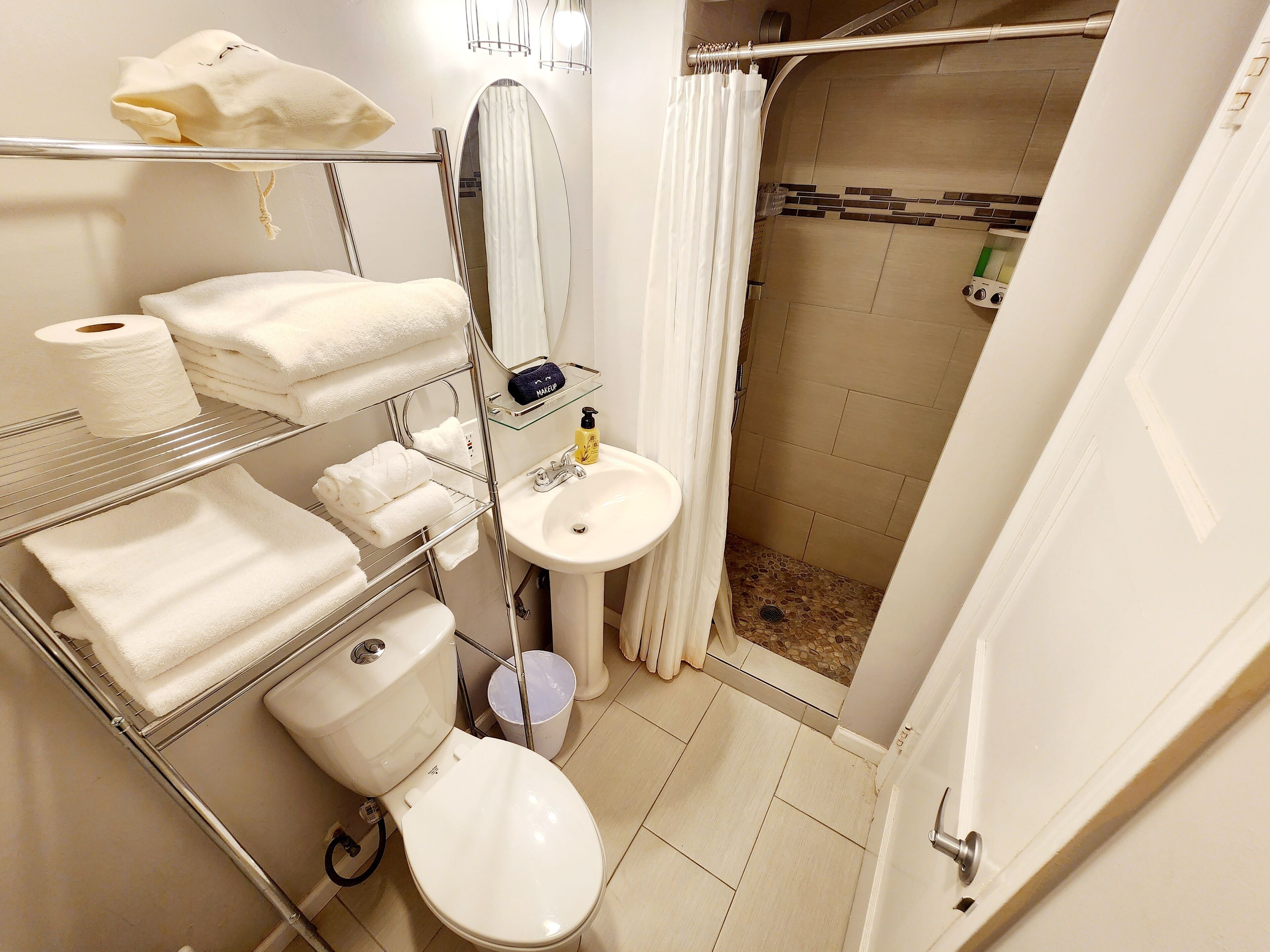 Een badkamer met toilet, wastafel en douche.
