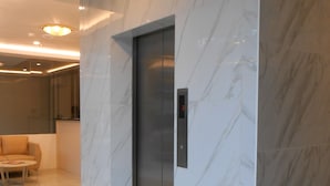A modern elevator in a lobby with marble walls and a clean, minimalist design. - Rublin Hotel (Cebu City)