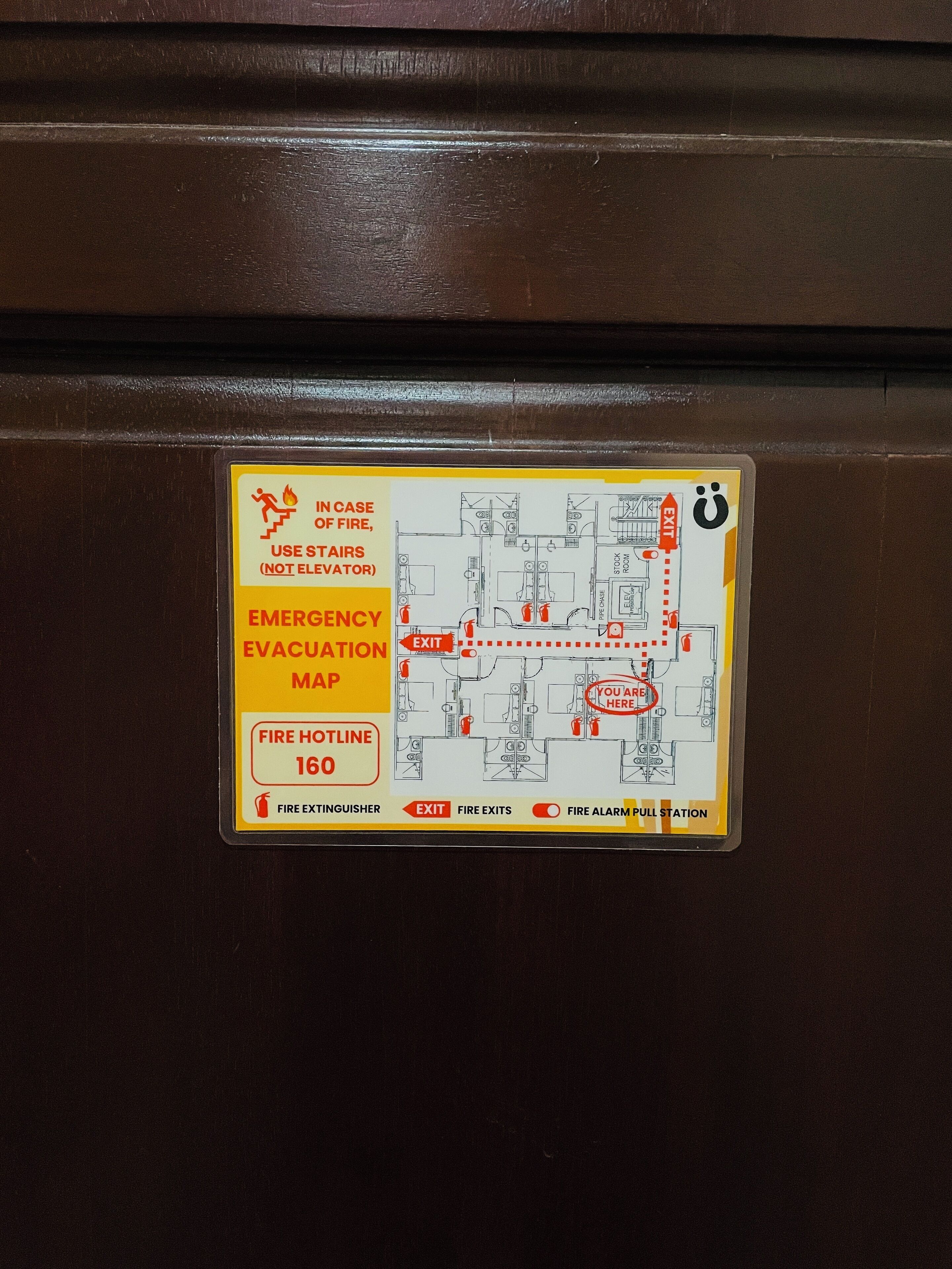 An emergency evacuation map with a fire hotline number and exit routes.