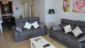 A living room with two grey sofas, a white coffee table, and a floor lamp.