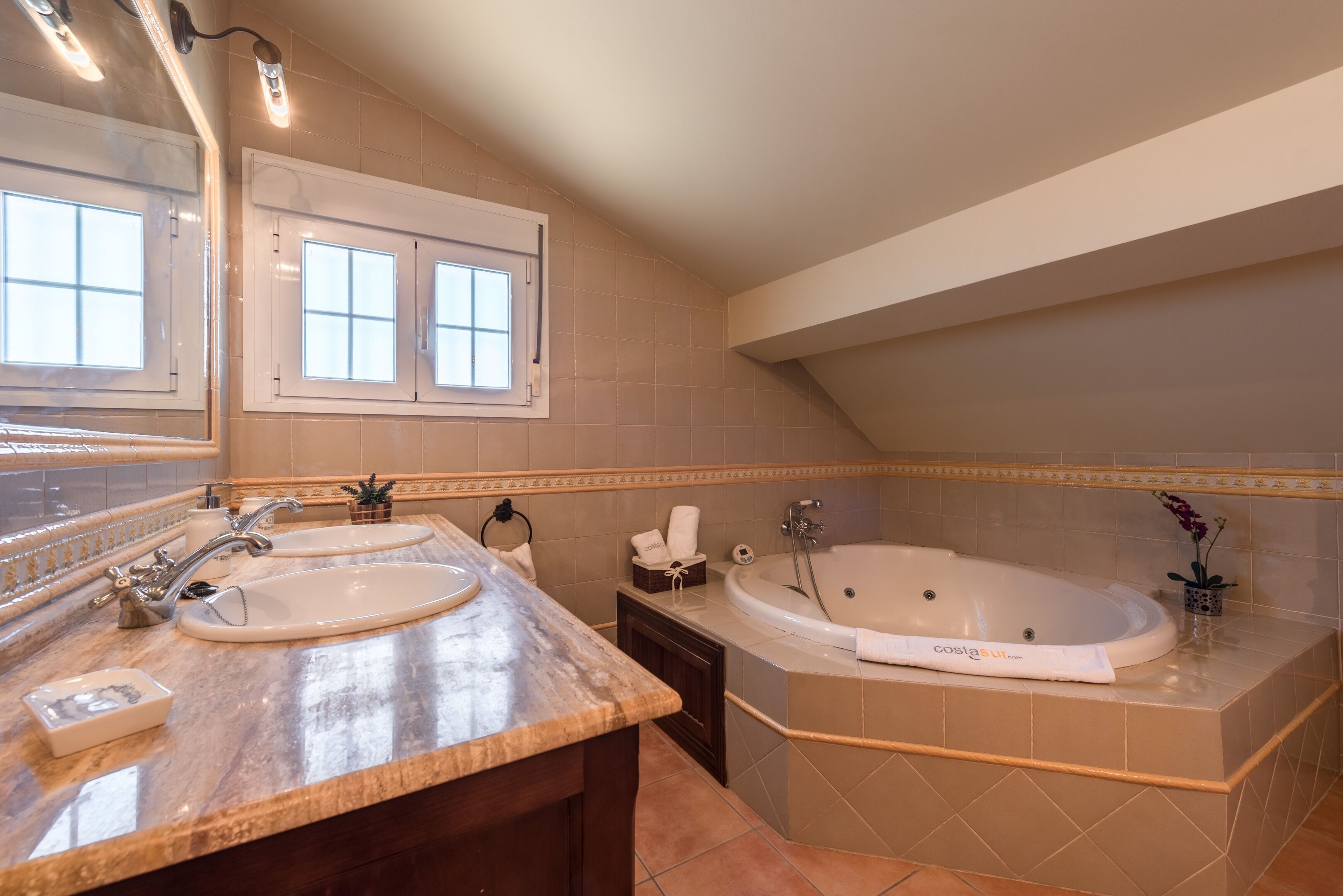 Une salle de bain avec deux éviers, une baignoire et une fenêtre.