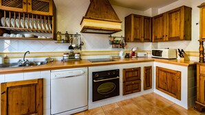 A kitchen with wooden cabinets, a dishwasher, an oven, and a microwave.