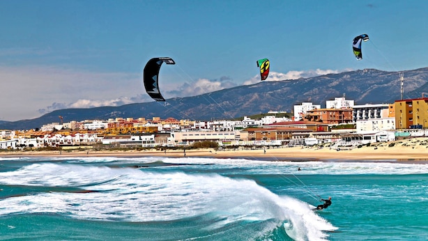 A coastal town with buildings, a beach, and a person kite surfing. - Centrally located apartment for 6,Tarifa (TARIFA)