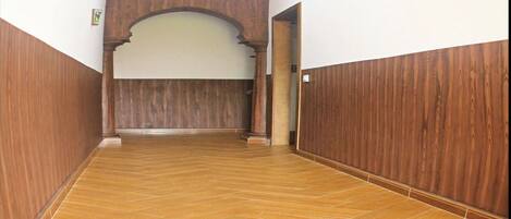 A hallway with wooden paneling and herringbone-patterned flooring.