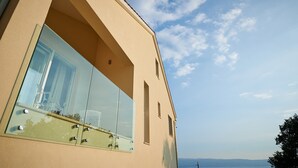 A modern building with large glass windows, a flat roof, and a clear view of the sky. - Luxury Villa Venera with Pool (Jesenice)